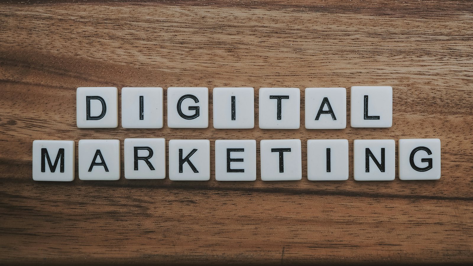 Letter tiles spelling digital marketing on a wooden table