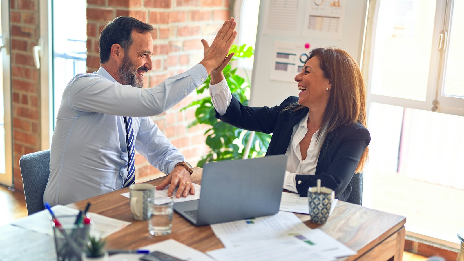 Two team members celebrating a result during a planning meeting